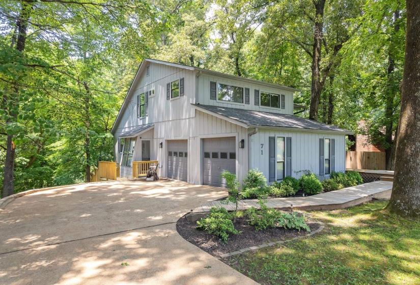 Contemporary two-story residence with light gray siding and dark gray shutters