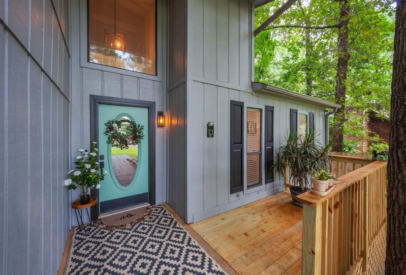 Board and batten siding exterior featuring a light teal oval-lite entry door with dark trim
