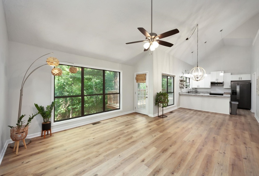 Open-concept living space featuring wood-finish flooring and a vaulted ceiling