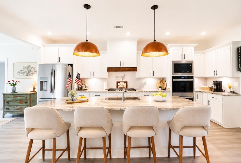 Kitchen featuring white cabinetry, light-toned countertops, and wood-finish flooring