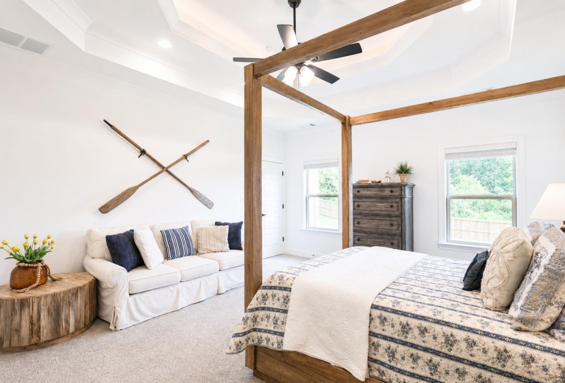 Spacious room featuring a tray ceiling with recessed lighting and a ceiling fan