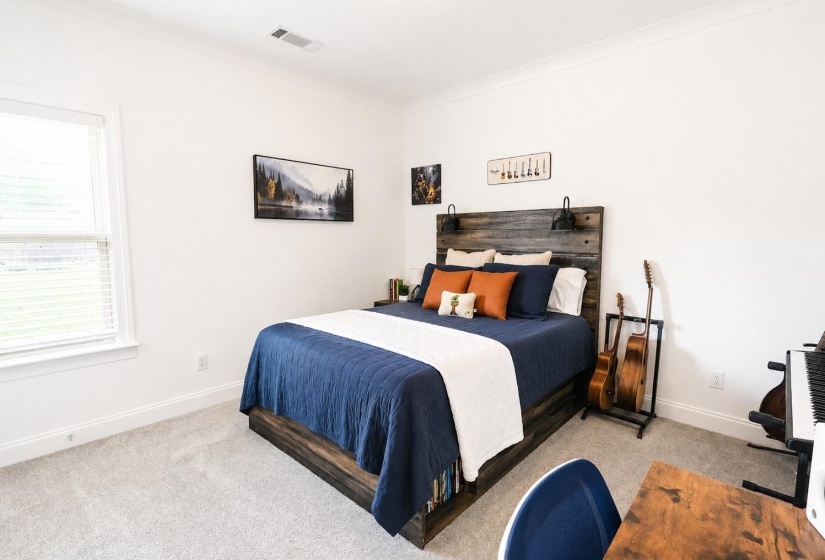 Spacious room featuring light gray carpeting, crisp white walls, white trim, and crown molding