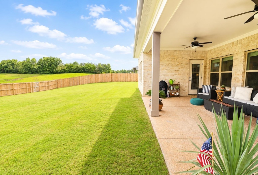 Expansive backyard with a full privacy fence and direct access to a covered patio