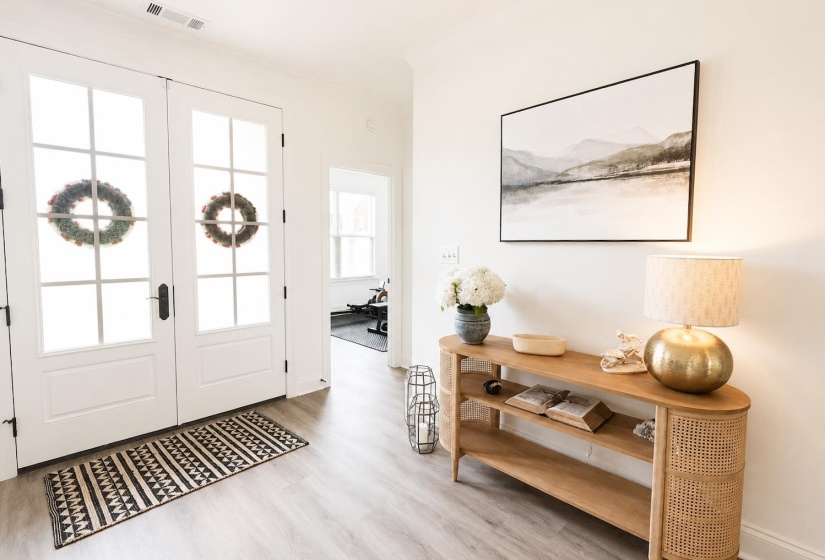 Entryway featuring double doors with divided lites, light wood-finish flooring, and crisp white wall tones