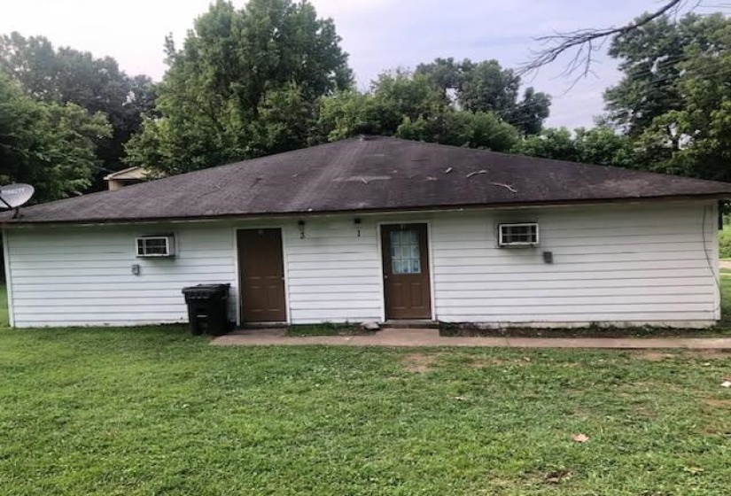 Single-story property with white siding and a dark shingle roof