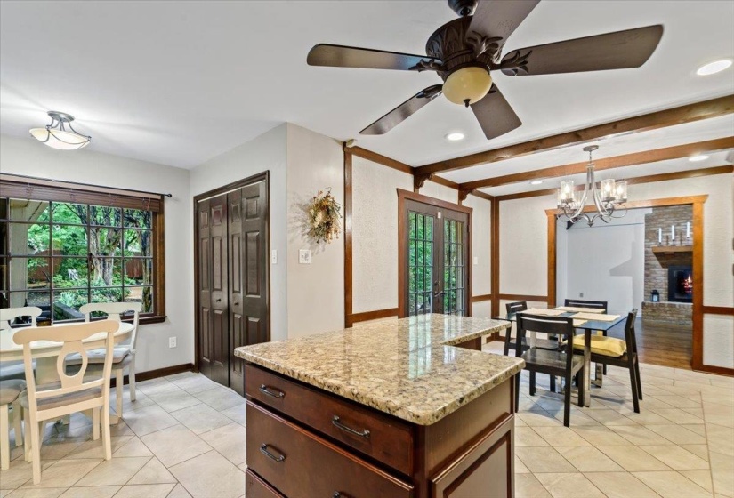 Kitchen featuring recessed lighting, light stone countertops, light tile patterned flooring, hanging light fixtures, and french doors