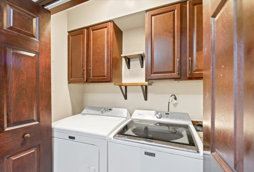 Clothes washing area with cabinet space and washer and clothes dryer