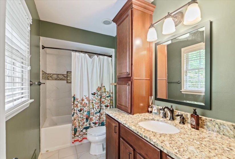 Bathroom with shower / bath combo, vanity, toilet, and tile patterned flooring