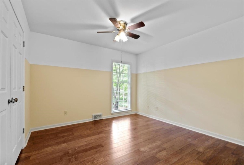 Spare room featuring visible vents, ceiling fan, wood finished floors, and baseboards