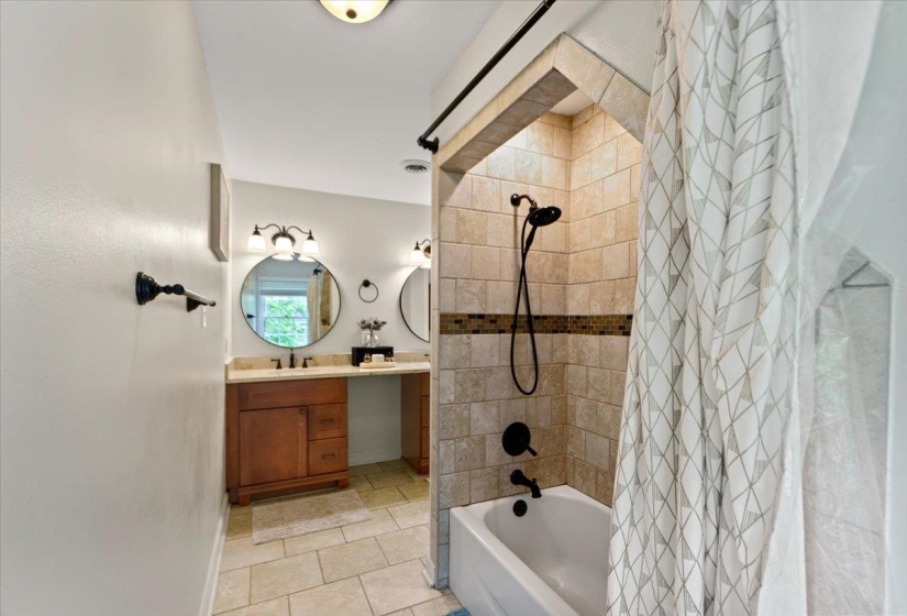 Full bath with vanity, shower / bath combination with curtain, visible vents, baseboards, and tile patterned flooring