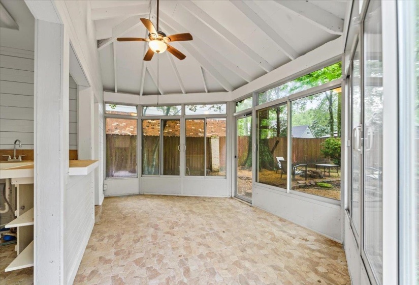 Unfurnished sunroom featuring beam ceiling, a healthy amount of sunlight, and a ceiling fan