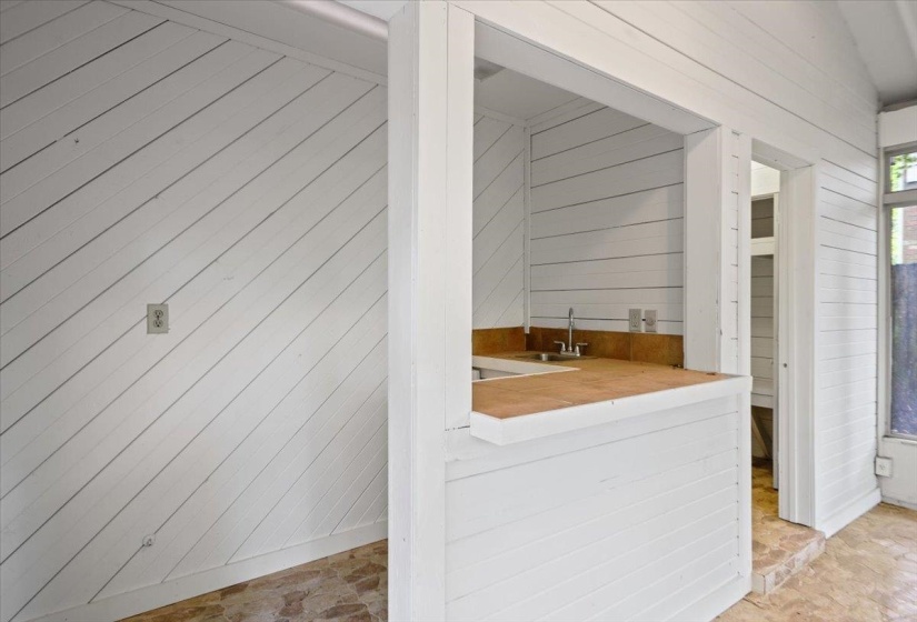 Interior space with wood walls, indoor wet bar, and a sink