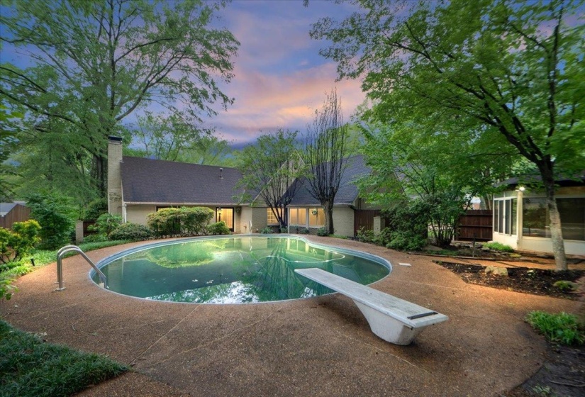 Outdoor pool with fence and a diving board