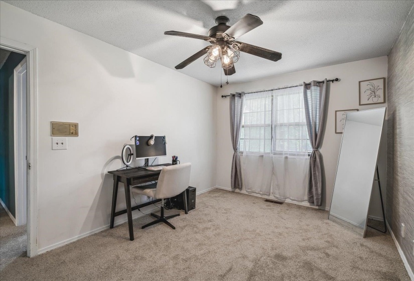 Carpeted interior room with a ceiling fan light fixture