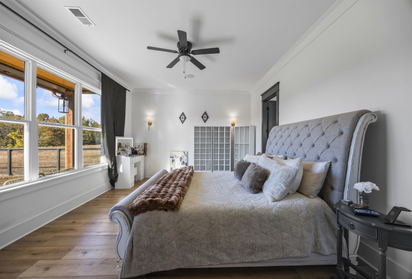 Spacious room with wood-finish flooring, white walls, and crown molding
