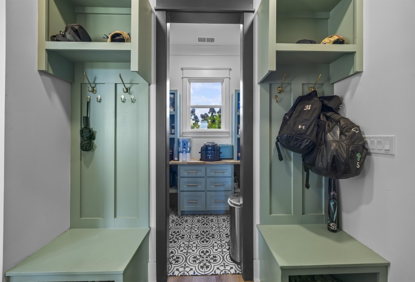 Built-in mudroom storage featuring two separate sections with hooks, open shelving, and integrated bench seating