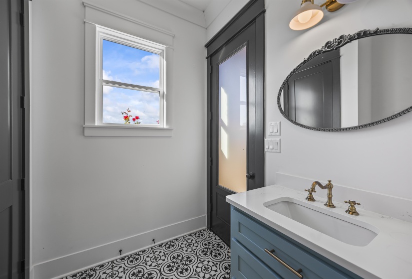Bathroom vanity featuring a light blue cabinet, white countertop with an integrated sink, and brass-finish faucet