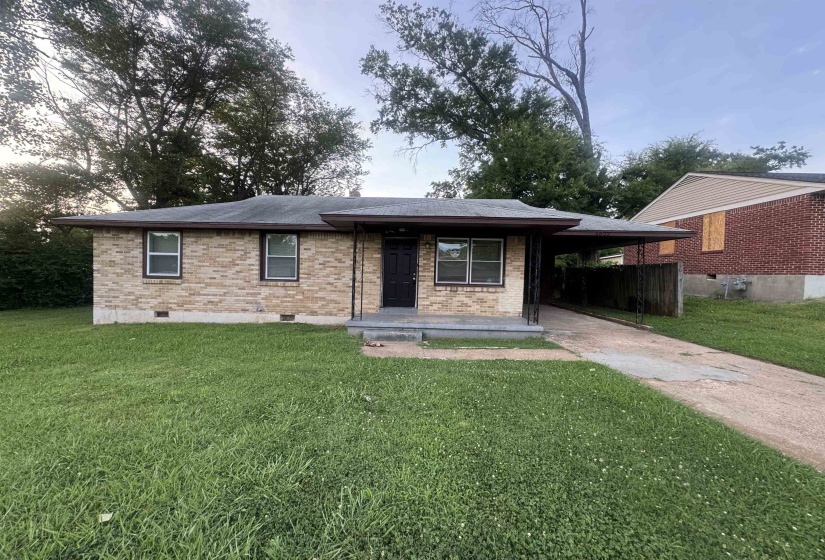 Brick exterior with a covered entryway and carport