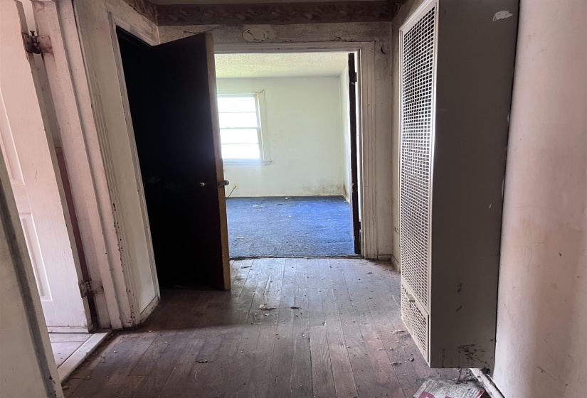 Hallway with wood-finish flooring and a wall-mounted heating unit