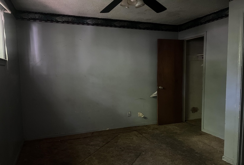 Interior room featuring a ceiling fan, wall-mounted light switch, and a brown interior door