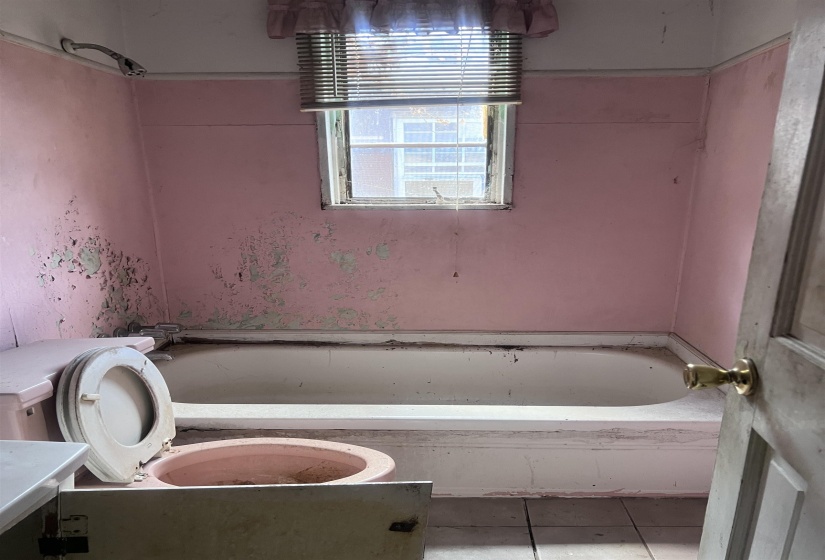 Bathroom featuring an integrated bathtub and an overhead window