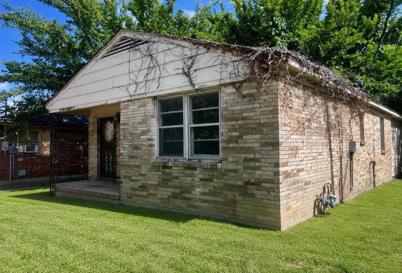 Brick exterior with a gabled roofline, multiple windows, and a covered front entry
