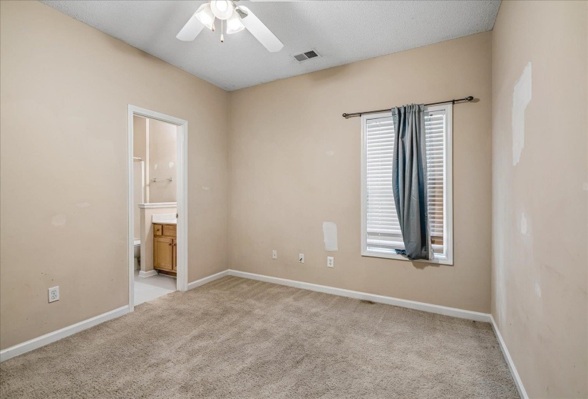 Carpeted room with a window featuring horizontal blinds, recessed baseboards, and a ceiling fan