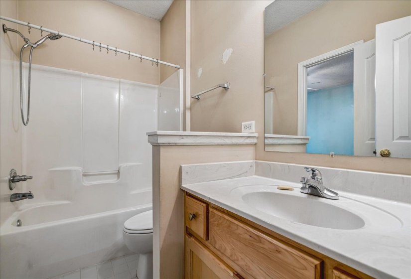 Bathroom featuring a single vanity with wood-finish cabinetry and an integrated white countertop and sink