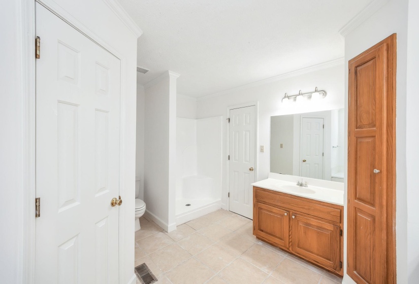 Bathroom featuring a wood-finish vanity with an integrated sink and a large mirror