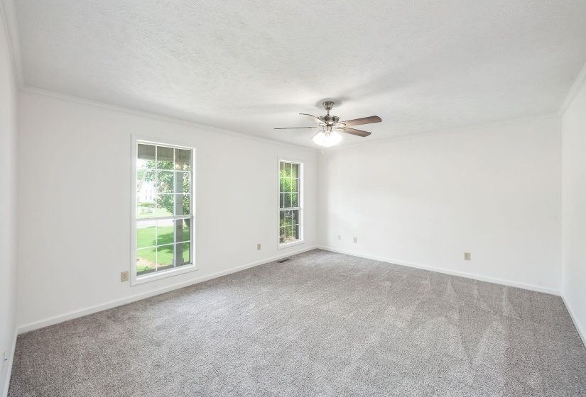 Spacious room with light gray carpeting and white walls