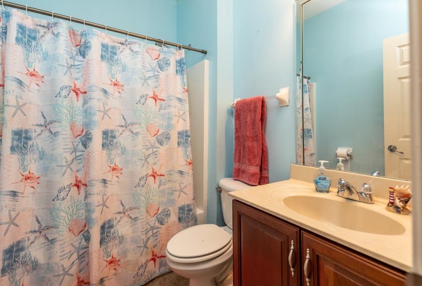 Bathroom featuring a light blue wall color, a built-in vanity with a cream-colored countertop, and a built-in mirror