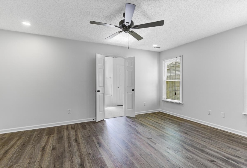 Spacious room featuring wood-finish flooring, light gray walls, and white trim
