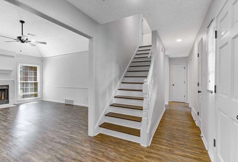 Staircase entry featuring wood-finish treads and white risers