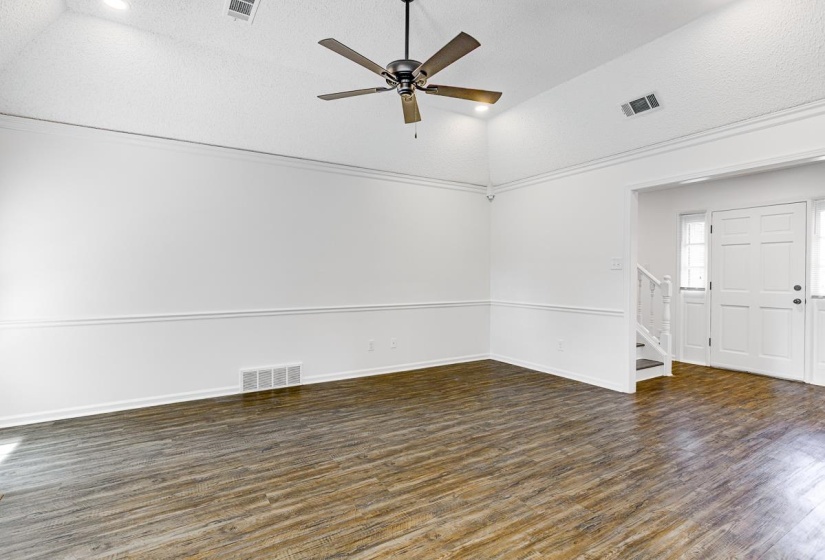 Spacious interior featuring wood-finish flooring, vaulted ceilings, and a ceiling fan