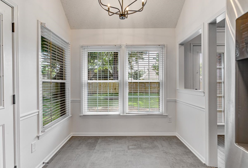 Bright interior space with vaulted ceiling and a contemporary chandelier
