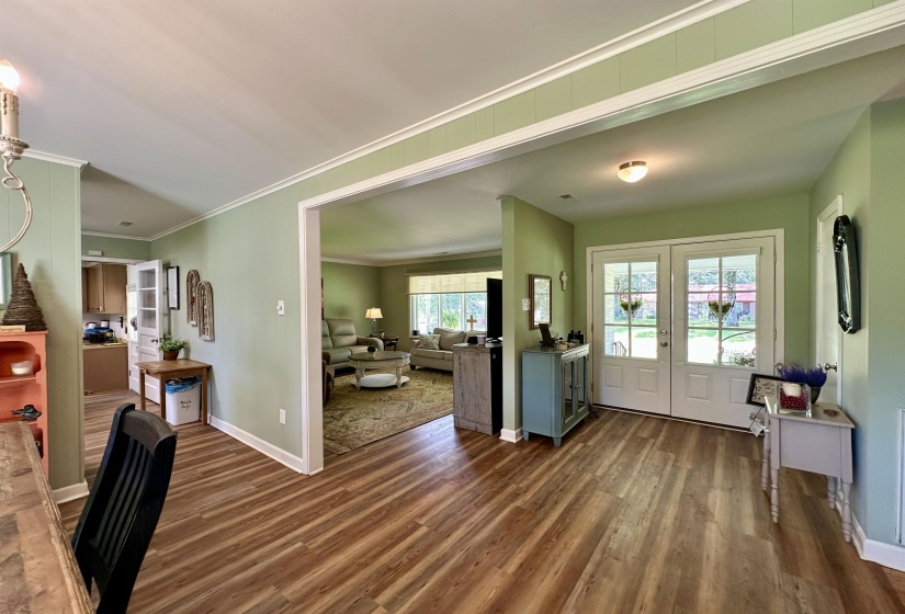 Wood-finish flooring extending from the entryway through an open archway