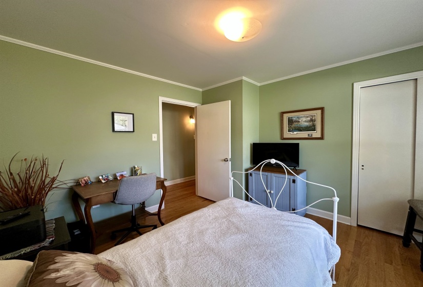 Hardwood-style flooring throughout this room with light green painted walls and white crown molding