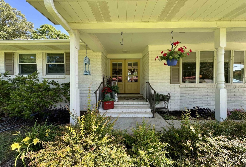 Brick exterior with a covered porch featuring white columns and a railing