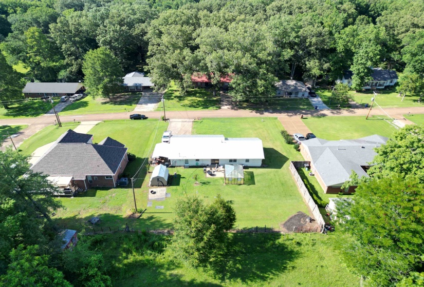 Single-story residence with a white exterior, gray roof, and a substantial green lawn