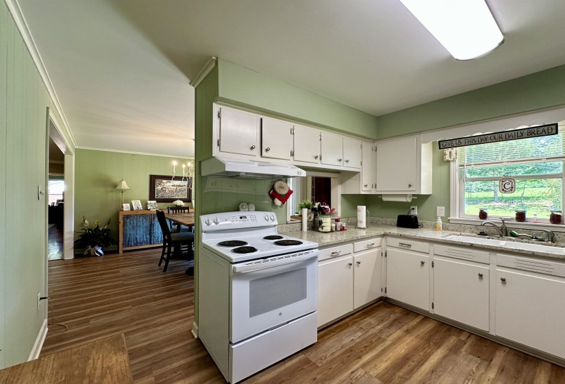 Kitchen featuring white cabinetry, light-colored countertops, a double basin sink, a white electric range, and wood-finish flooring