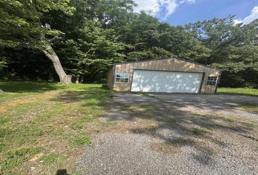 Freestanding garage with a light-toned wood-finish exterior and a white overhead door