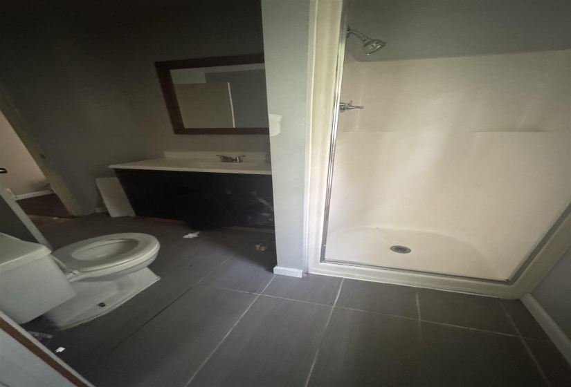 Bathroom featuring a walk-in shower with a glass enclosure, white shower surround, and a chrome shower head