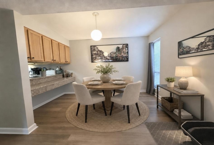 Dining area featuring wood-finish flooring, a contemporary pendant light and extra counter seating