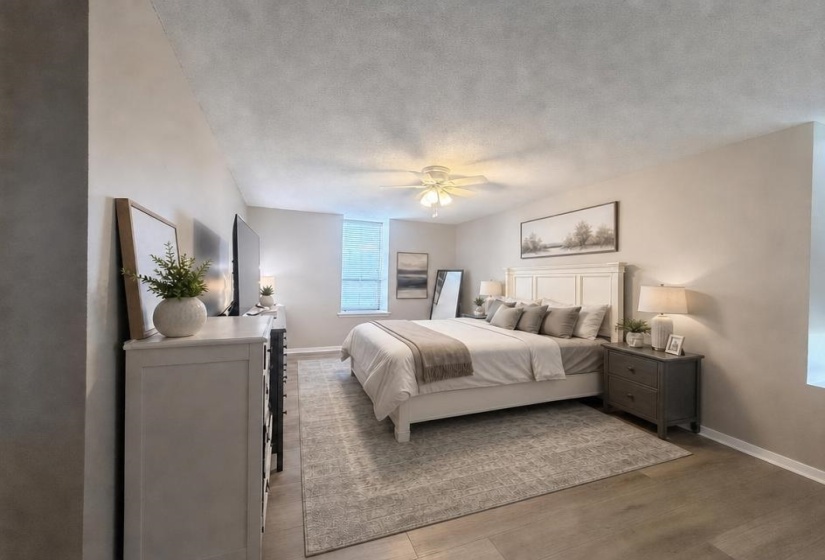 Spacious room featuring wood-finish flooring, a ceiling fan, and light-toned walls