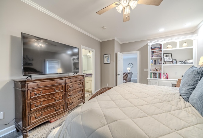 Spacious bedroom featuring crown molding, recessed lighting, a ceiling fan, and built-in shelving with integrated lighting