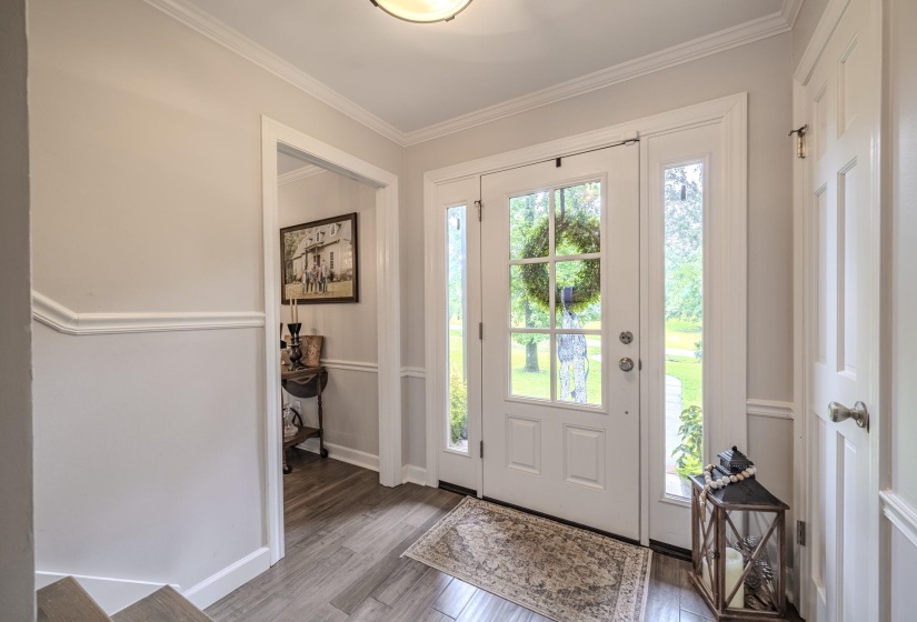 Entryway featuring a white paneled front door with multiple glass lites, sidelight windows, and transom window
