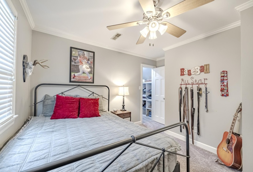 Bedroom featuring light gray walls, white crown molding, and gray carpet flooring