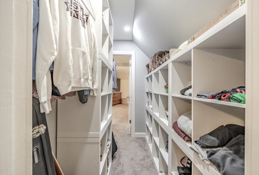 Custom closet system featuring built-in shelving, hanging rods, and recessed lighting