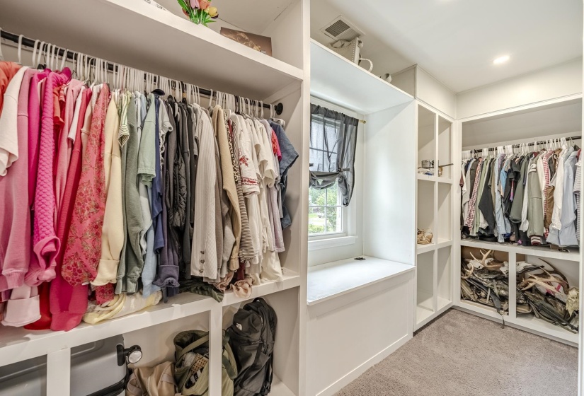Custom closet organization system featuring multiple hanging rods and integrated shelving