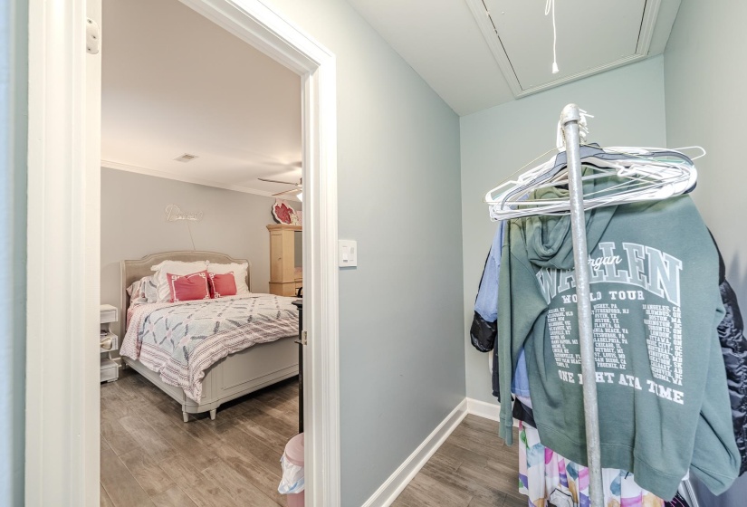 Interior bedroom featuring wood-finish flooring, a ceiling fan, and crown molding